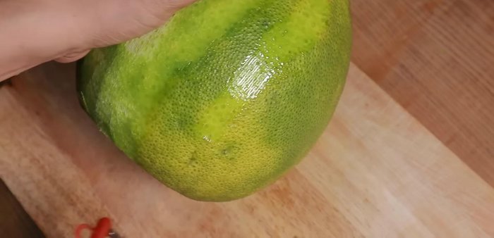 Peel off the thin outer green skin of the pomelo to reduce bitterness.