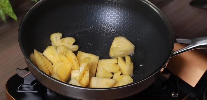 Stir-fry the pineapple with 1 tablespoon of sugar until bright yellow.