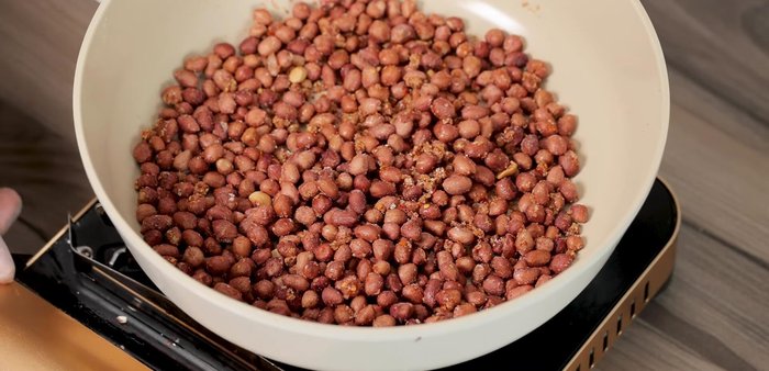 Turn off the heat. Cover the pan with a towel to let the peanuts cool naturally.