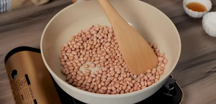 Roast peanuts over low heat until golden and fragrant, and easily peeled. Be patient and gentle.