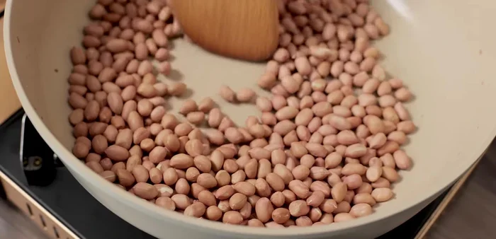 Add cooking oil (1/2 teaspoon). Roasting the peanuts with oil at the beginning prevents them from peeling easily but may shorten their shelf life.