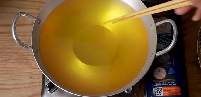 Heat oil in a frying pan over low heat. Test if it's ready by checking if it bubbles around chopsticks.