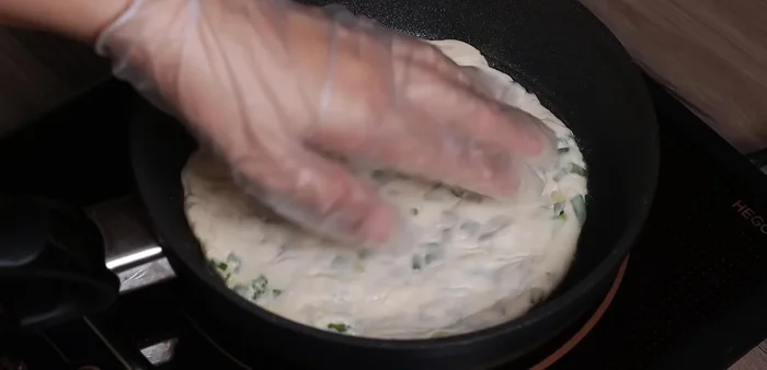 Cook the cake until the top is clear, then flip and cook the other side until golden brown.