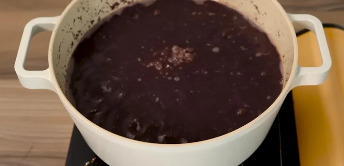 Add 180-200g rock sugar to the cooked beans. Add the cooked tapioca pearls, stir well, and cook for about 5 minutes to allow the pearls to absorb the sugar and flavors.