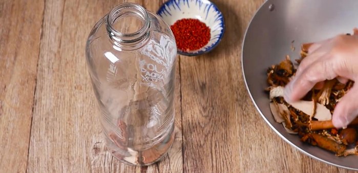 Once the ingredients have cooled, add them to the bottle, along with the chrysanthemum.
