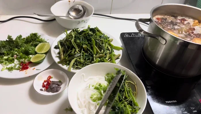 Assemble the soup: Add noodles, crab cakes, broth, and garnishes to individual bowls.