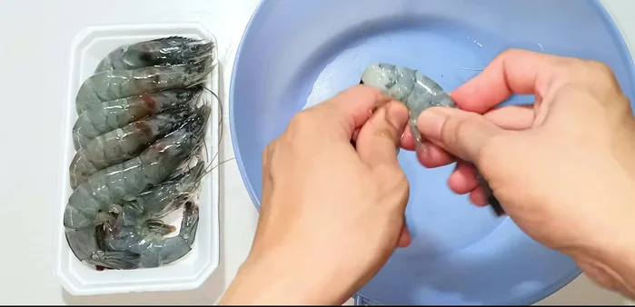 Remove the heads and peel the shrimp shells. Cut along the back of the shrimp to remove the shrimp vein. Wash the shrimp again.
