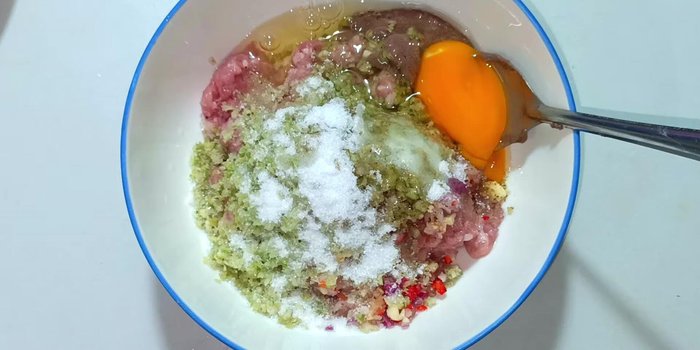 Crack two eggs into the meat mixture and mix thoroughly.