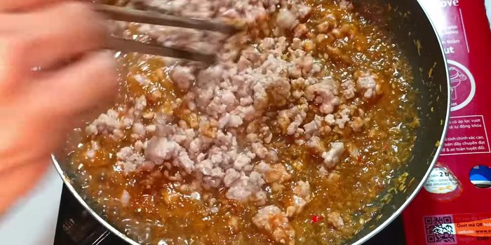 Add the cooked minced meat. Stir well and cook until the shrimp paste dries up and the dish turns darker. Turn off the stove and let it cool slightly.