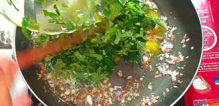 Pour egg mixture into the pan. Spread lolot leaves evenly over the surface of the eggs using a spatula.