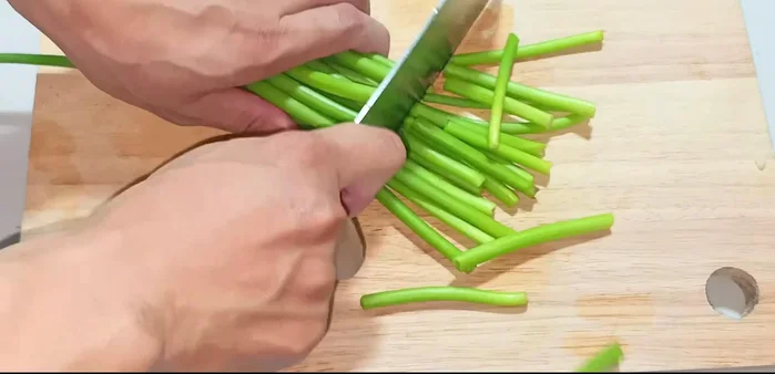 Cut off about 4-5 cm of the old white part of the green onions and divide the top green part into 4-5 cm pieces.