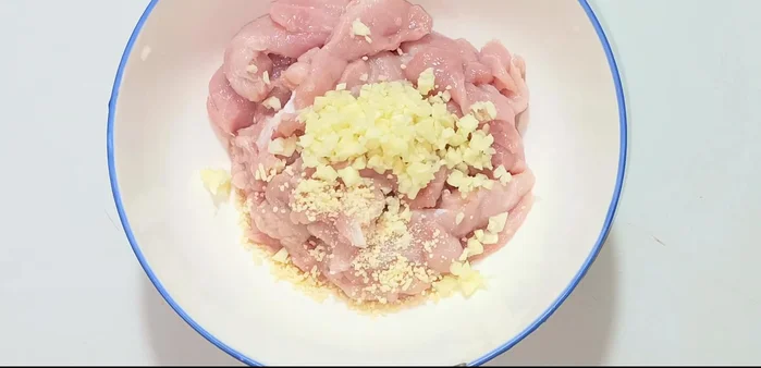 Marinate the pork with minced garlic, seasoning powder, MSG, pepper, sugar, and fish sauce. Marinate for 20 minutes.