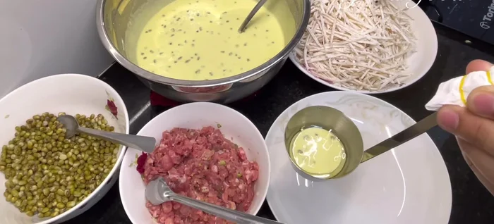 Add a thin layer of batter to the mold, followed by the taro, ground meat, mung beans, and shrimp. Top with another thin layer of batter.