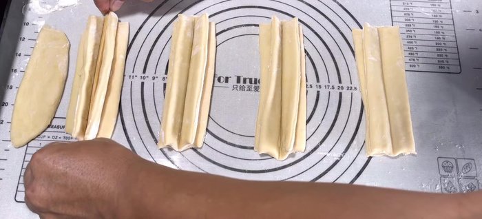 Heat oil in a flat-bottomed pan over medium-low heat until it shimmers. Gently add the dough sticks, stretching them slightly as you place them in the hot oil.