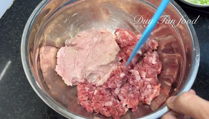 Prepare the meat mixture: Combine the raw ham (previously frozen for 15 minutes), ground lean meat, corn kernels, chopped onion, chili, garlic powder, onion powder (or fresh minced garlic and onion), sugar, seasoning powder, MSG (optional), pepper, salt, and oyster sauce (or fish sauce). Mix well, then wear gloves and knead thoroughly.