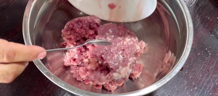 Mix the meat and ingredients: Combine ground pork, ground beef, pork liver, vermicelli, wood ear mushrooms, black mushrooms, beans, carrots, fried garlic, black pepper, sugar, seasoning powder, MSG (optional), and salt. Mix well until evenly distributed. (76.28)