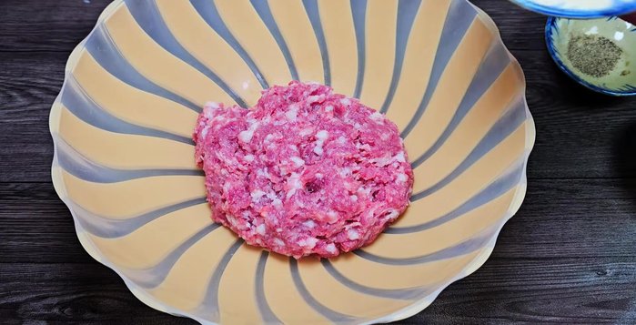 In a bowl, combine the minced meat, chopped green onion roots, bone broth, pepper, MSG, and sugar. Mix well to marinate the meat.
