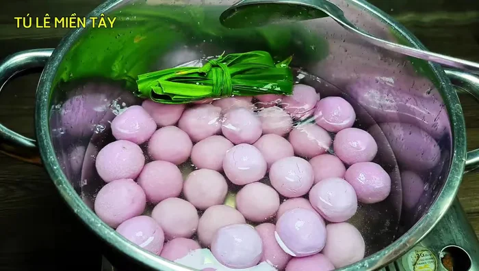 Add the taro balls and pandan leaves to the boiling sugar water. Stir gently to prevent sticking.