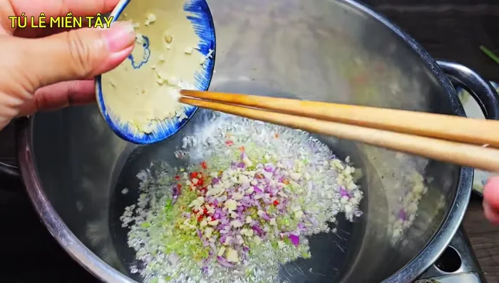 Heat cooking oil in a pot. Add lemongrass, chili, shallots, and garlic; fry until fragrant.