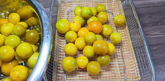 Drain the kumquats in a basket to remove excess water. This prevents spoilage.