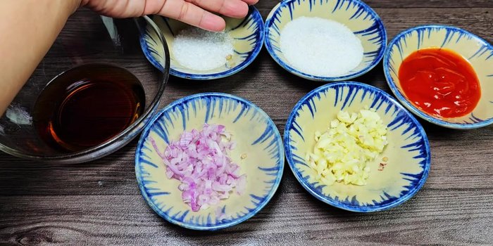Prepare the sauce: Mix fish sauce, MSG, sugar, minced shallots, minced garlic, and chili sauce.