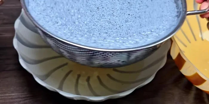 Drain the excess water from the soaked basil seeds using a strainer or colander.
