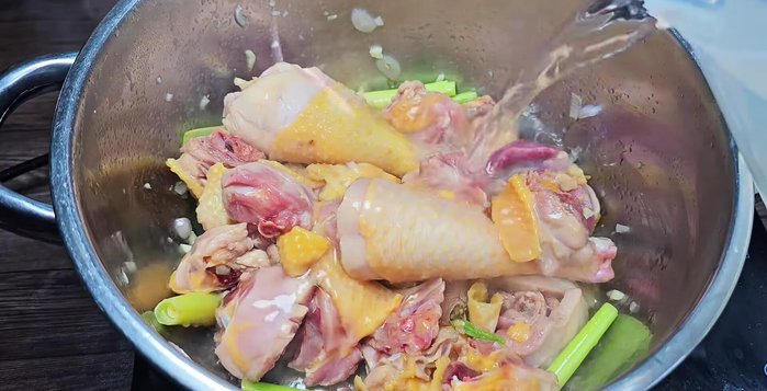 Add coconut water and broth: Pour in 1.5 liters of fresh coconut water and bring to a boil. Skim off any foam.