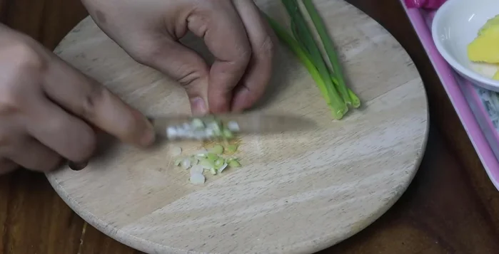 Finely chop the green onion heads and leaves separately. Fry the green onion leaves in a pan with half a tablespoon of satay oil (or substitute cooking oil with chili or annatto oil) until fragrant.
