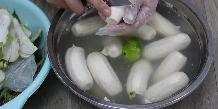 Soak peeled bananas: Submerge the peeled bananas in the prepared salt-lemon water to clean the sap and prevent discoloration.