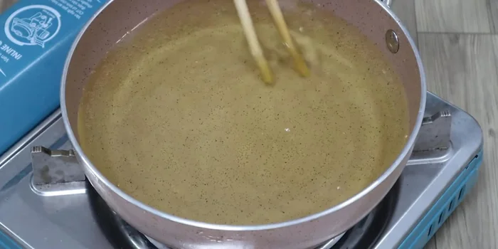 Fry bananas (first fry): Heat cooking oil in a pan. Add the grated bananas and fry until they are firm and dry, then separate any stuck pieces.