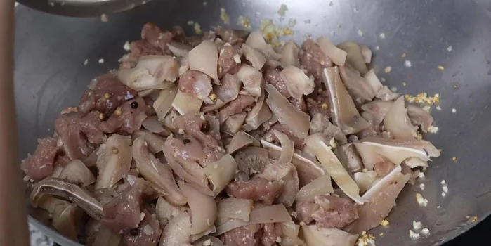 Stir-fry the mixture: Stir-fry the remaining half of the minced garlic until fragrant. Add the marinated meat mixture and stir-fry over low heat until fragrant and the meat firms up. Add water or coconut water and continue stir-frying for 10 more minutes. Add wood ear mushrooms and stir-fry for another 5 minutes.