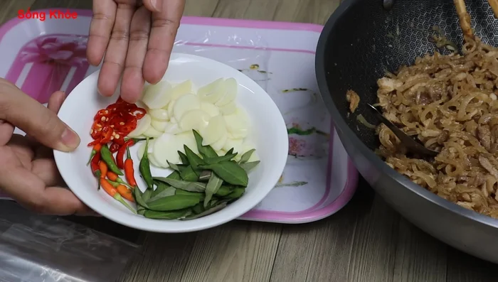 Assemble the spring rolls: Prepare rice paper, sliced garlic, chili, and Vietnamese coriander (optional). Fill the rice paper with the pork and pork skin mixture, adding your preferred condiments.