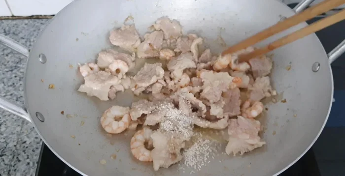 Add seasoning powder, MSG, sugar, oyster sauce, and pepper to the pan. Stir-fry until well combined.