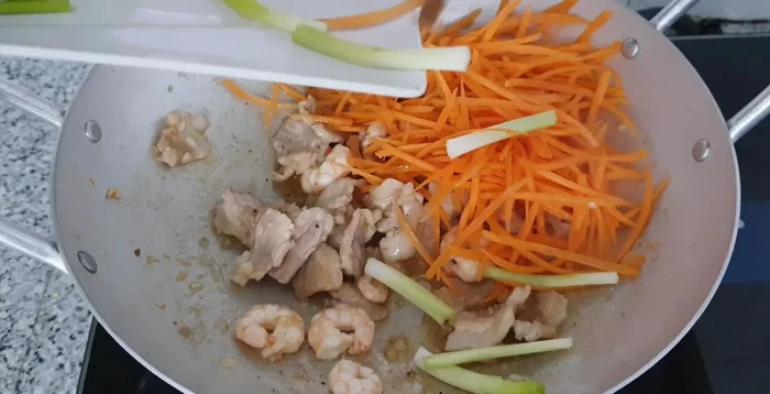 Add carrots and stir-fry until cooked. Then, add bean sprouts and chives. Stir-fry for about a minute.