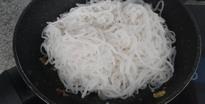 Add noodles to the pan and stir-fry. Add the stir-fried vegetable and meat mixture, along with some of the cooking liquid.