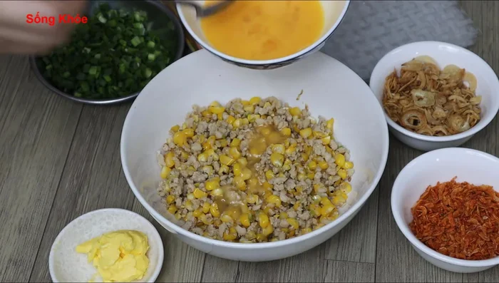 Pour half of the whisked egg into the pork and corn mixture.