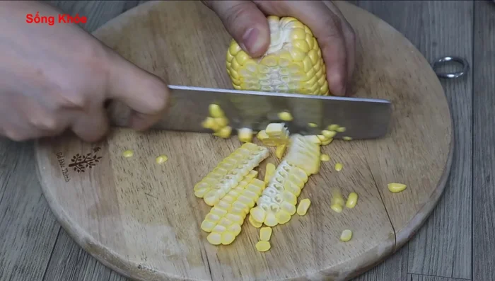 Cut the corn into two layers, keeping the kernels intact for sweetness. Cut the corn into four pieces.