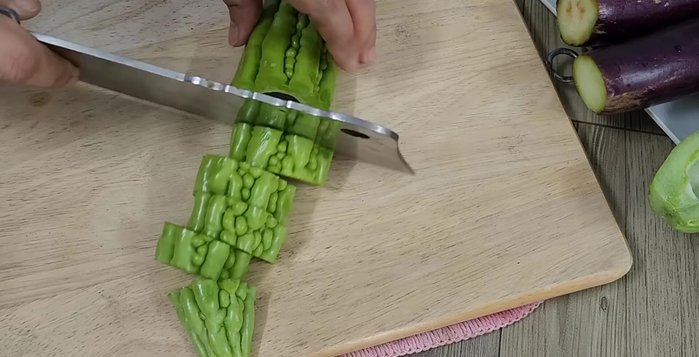 Prepare the bitter melon and eggplant by removing seeds and cutting into bite-sized pieces.