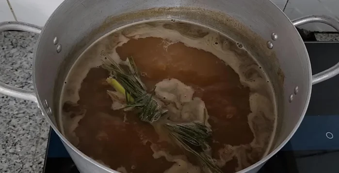 Transfer the stir-fried meat and shrimp to the fish sauce pot. Add the garlic and lemongrass from the pan.