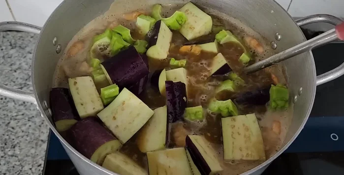 Add eggplant and bitter melon. Stir gently. Add the fish last and let it simmer until cooked through.