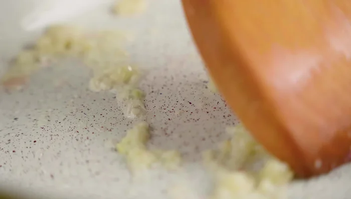 Fry minced garlic, then add homemade liver paste and stir until dissolved.