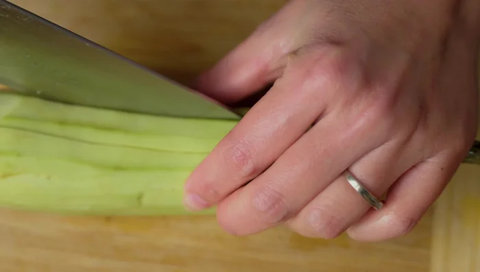 Cut eggplants into thin strips, alternating horizontal and vertical cuts.