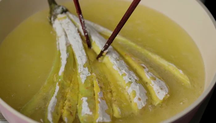 Fry eggplants in hot oil until golden and crispy.