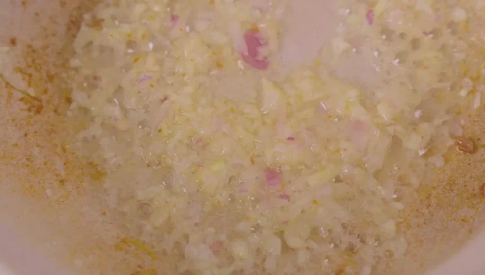 Add half of the onion and garlic mixture to the pot and stir-fry, then add pickled mustard greens and stir-fry for 1 minute. Remove and set aside.