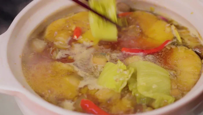 Simmer for about 5 minutes, then add the pickled mustard greens.