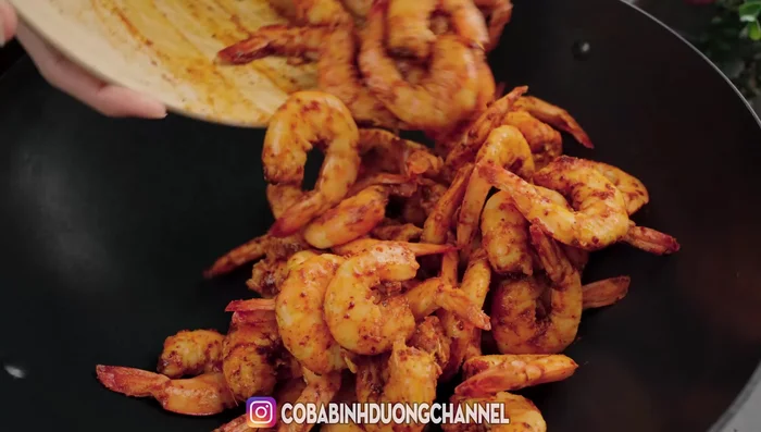 Stir-fry shrimp over low heat until fragrant and spices are absorbed.