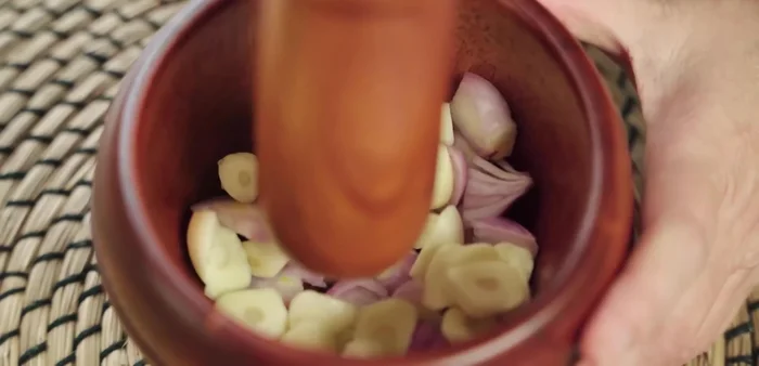 Pound onions and garlic in a mortar. Alternatively, grind or chop them.