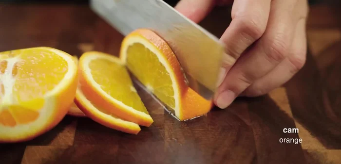 Cut a small yellow orange into pieces.