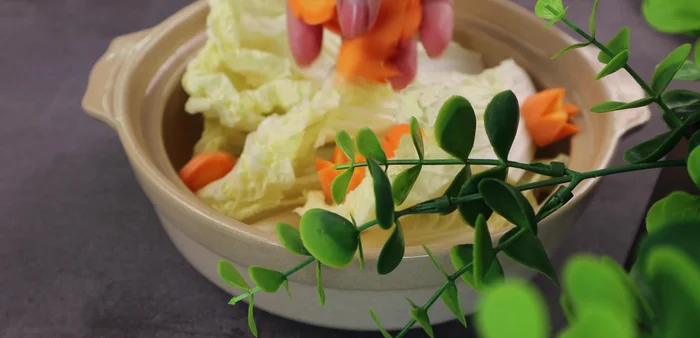 Add the cabbage and carrots to a pot. Remove the chicken bones from the broth after 30 minutes of simmering. Pour the chicken bone broth into the pot with the cabbage and carrots. Bring to a boil.