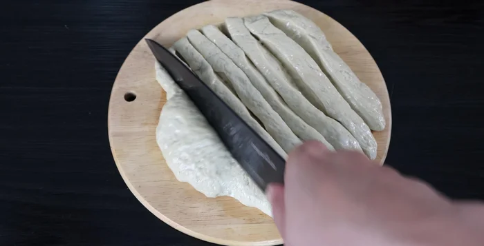 Oil a knife and cut the seitan into smaller pieces. Oil chopsticks and roll seitan pieces around them to create a stick shape.